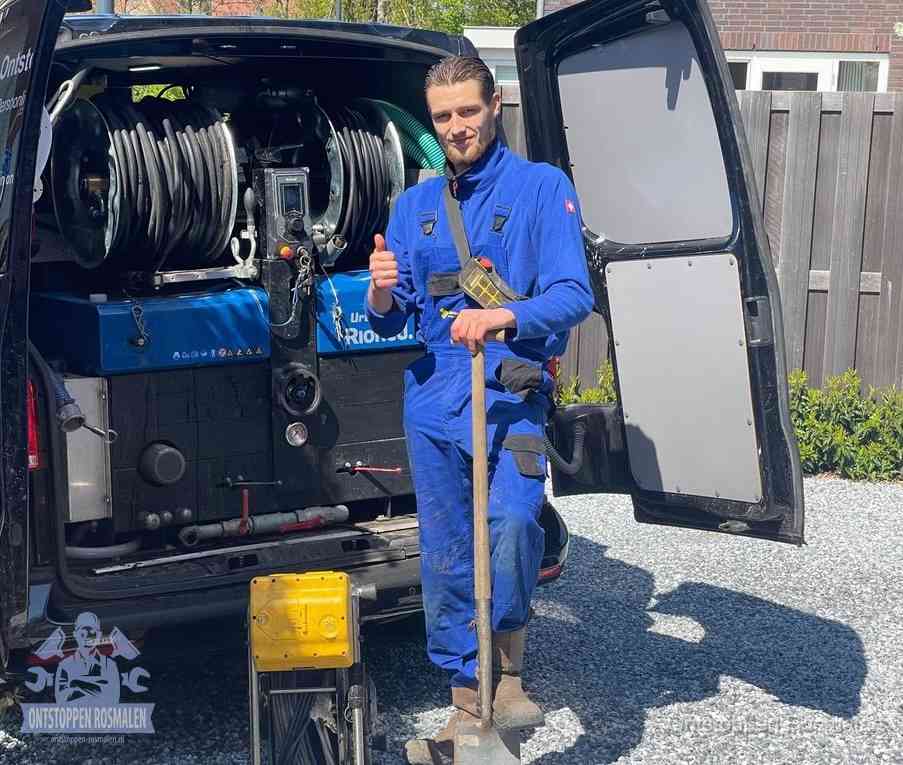 Een monteur bij de werkbus met grote hogedruk-slanghaspels, apparatuur voor hardnekkige afvoerverstoppingen in Rosmalen