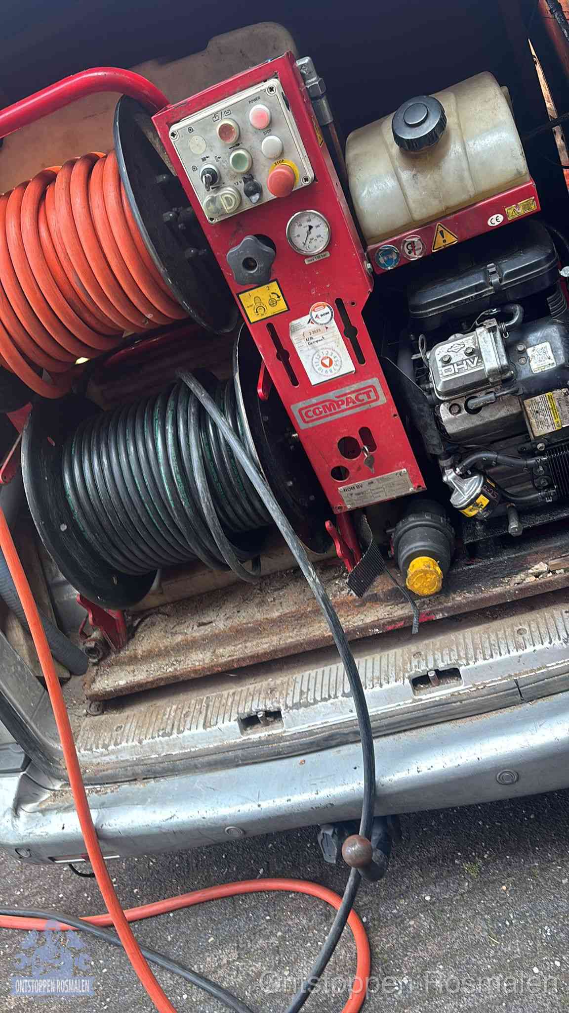 Een rood hogedruk-rioolreinigingstoestel met slangen in de laadbak van de bedrijfsbus, apparatuur voor een hardnekkige wc-verstopping in Rosmalen
