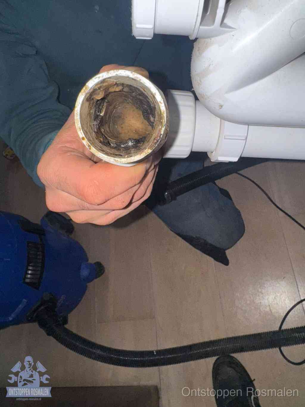 Een losgekoppelde afvoerbuis die van binnen volledig is dichtgeslibd met vet en aanslag, de meest voorkomende oorzaak van een verstopte gootsteen in Rosmalen