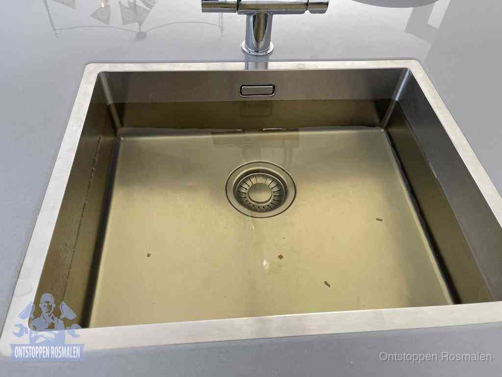 Stilstaand water in een rvs spoelbak dat niet wegloopt, een duidelijk signaal van een gootsteenverstopping in Rosmalen