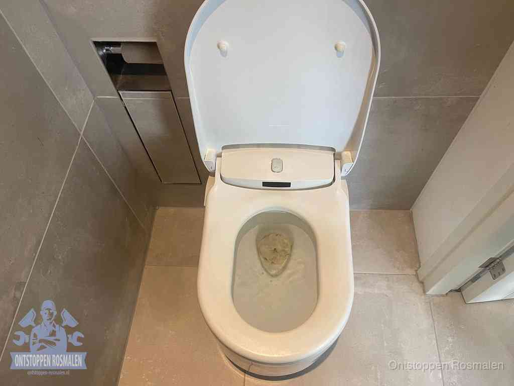 Een wit hangtoilet waarin een prop wc-papier op het water blijft drijven, een duidelijk signaal van een verstopte wc in Rosmalen