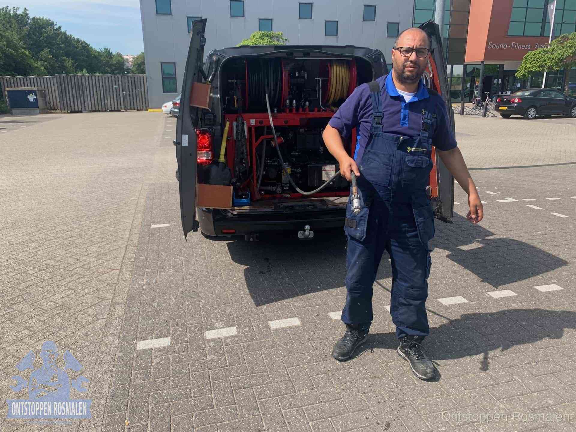 Een monteur bij zijn bestelbus met een hogedruk- en rioolreinigingsunit, klaar om de oorzaak van terugkerende wc-verstoppingen aan te pakken in Rosmalen